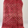 Alfombra bereber vintage en rojo intenso con patrón de rombos en crema y negro, tejida a mano en lana gruesa, sobre suelo claro