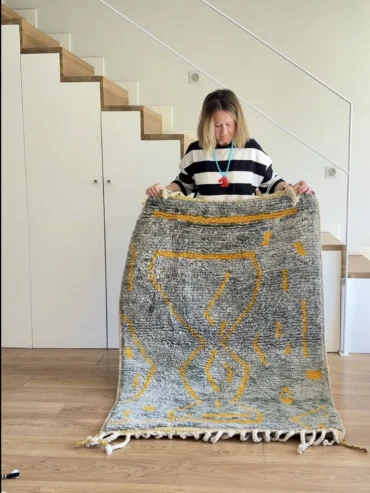 Alfombra bereber gris Beni Ouarain con líneas mostaza, de lana gruesa y formato pequeño.