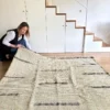 Alfombra kilim verde de lana tejida a mano con franjas negras sobre suelo de madera clara