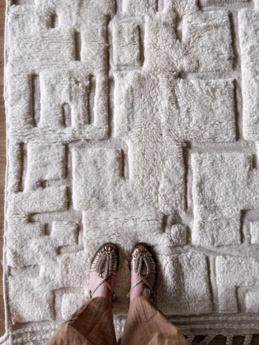 Alfombra bereber pequeña de lana blanca con patrón en relieve geométrico, tejida a mano en Marruecos