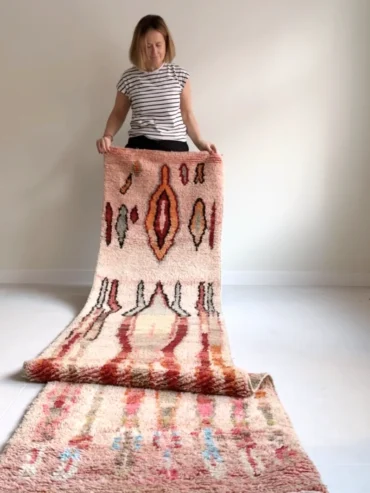 Alfombra marroquí pasillera tipo Boujaad tejida a mano en tonos rosa, rojo y gris con diseño vertical