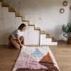 Alfombra bereber de lana con formas geométricas en tonos pastel sobre base cruda, ideal para espacios infantiles