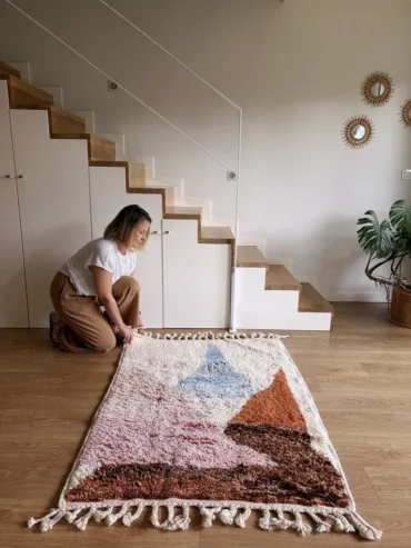 Alfombra bereber de lana con formas geométricas en tonos pastel sobre base cruda, ideal para espacios infantiles
