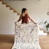 Alfombra artesanal blanca de lineas azules