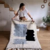 Alfombra bereber de lana en tonos azules y negros sobre fondo crudo, diseño infantil, tejida a mano