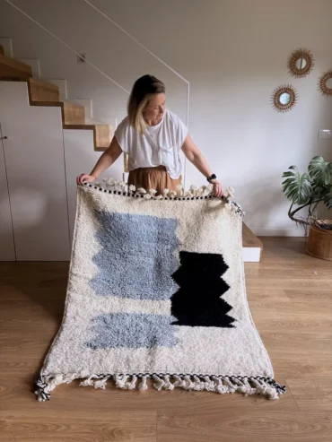Alfombra bereber de lana en tonos azules y negros sobre fondo crudo, diseño infantil, tejida a mano