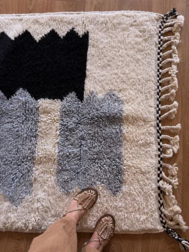 Alfombra bereber de lana en tonos azules y negros sobre fondo crudo, diseño infantil, tejida a mano