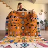 Alfombra marroquí étnica en tonos cálidos con diseño de rombos, tejida a mano en lana
