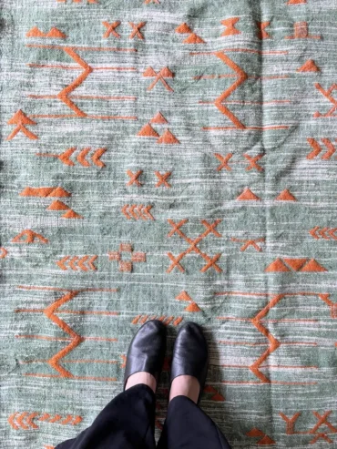 Kilim verde artesanal de lana tejida a mano con detalles en naranja y diseño bereber