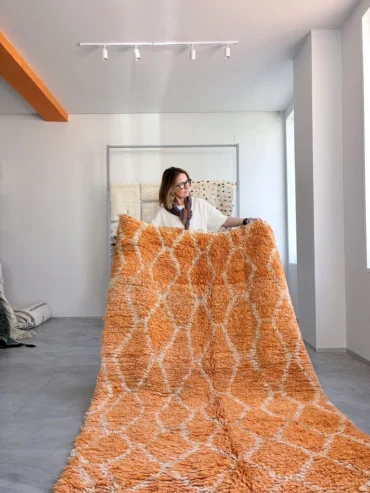 lfombra vintage de lana Desert Flame con rombos en tonos naranja y variaciones de color propias del uso, tejida a mano en Marruecos.